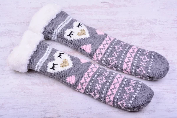 Ein Paar gestrickte Wollsocken auf weißem Holzhintergrund — Stockfoto