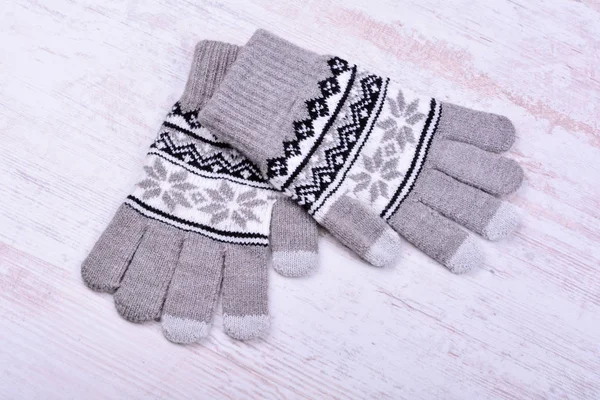 Une paire de gants tricotés hiver sur fond de bois blanc — Photo