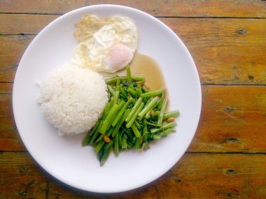 Gıda Tay Asya, yeşil sabah zafer bitkisel yağ ile ahşap masasına açık sunlighte, vejetaryen yemek, sağlıklı gıda, sarımsak yemek kızarmış.