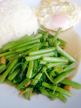 Gıda Tay Asya, yeşil sabah zafer bitkisel yağ ile ahşap masasına açık sunlighte, vejetaryen yemek, sağlıklı gıda, sarımsak yemek kızarmış.