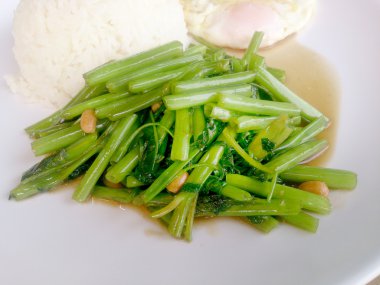 Gıda Tay Asya, yeşil sabah zafer bitkisel yağ ile ahşap masasına açık sunlighte, vejetaryen yemek, sağlıklı gıda, sarımsak yemek kızarmış.