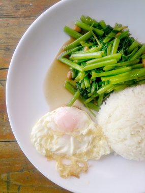Gıda Tay Asya, yeşil sabah zafer bitkisel yağ ile ahşap masasına açık sunlighte, vejetaryen yemek, sağlıklı gıda, sarımsak yemek kızarmış.