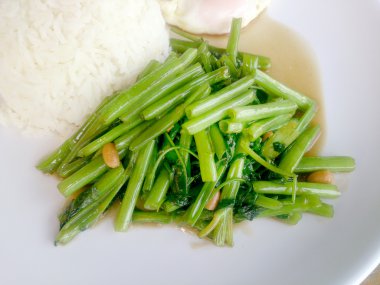 Gıda Tay Asya, yeşil sabah zafer bitkisel yağ ile ahşap masasına açık sunlighte, vejetaryen yemek, sağlıklı gıda, sarımsak yemek kızarmış.