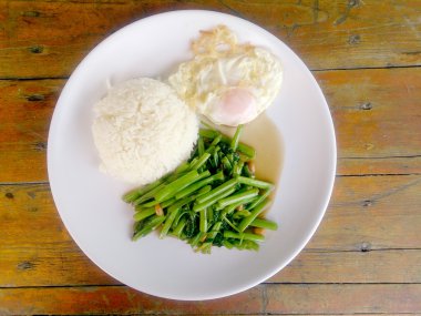 Gıda Tay Asya, yeşil sabah zafer bitkisel yağ ile ahşap masasına açık sunlighte, vejetaryen yemek, sağlıklı gıda, sarımsak yemek kızarmış.