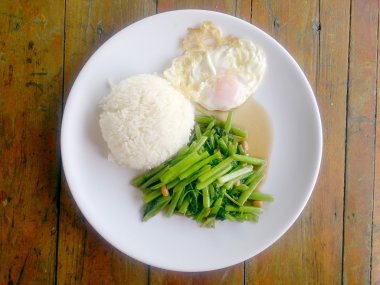 Gıda Tay Asya, yeşil sabah zafer bitkisel yağ ile ahşap masasına açık sunlighte, vejetaryen yemek, sağlıklı gıda, sarımsak yemek kızarmış.