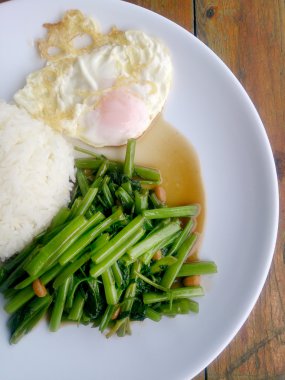 Gıda Tay Asya, yeşil sabah zafer bitkisel yağ ile ahşap masasına açık sunlighte, vejetaryen yemek, sağlıklı gıda, sarımsak yemek kızarmış.
