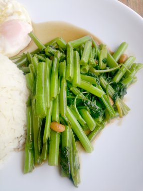 Gıda Tay Asya, yeşil sabah zafer bitkisel yağ ile ahşap masasına açık sunlighte, vejetaryen yemek, sağlıklı gıda, sarımsak yemek kızarmış.