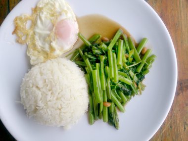 Gıda Tay Asya, yeşil sabah zafer bitkisel yağ ile ahşap masasına açık sunlighte, vejetaryen yemek, sağlıklı gıda, sarımsak yemek kızarmış.