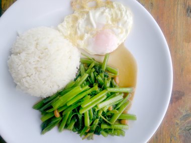 Gıda Tay Asya, yeşil sabah zafer bitkisel yağ ile ahşap masasına açık sunlighte, vejetaryen yemek, sağlıklı gıda, sarımsak yemek kızarmış.