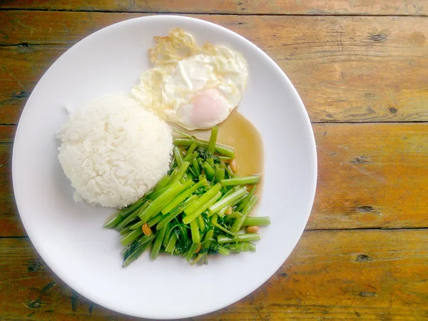 Gıda Tay Asya, yeşil sabah zafer bitkisel yağ ile ahşap masasına açık sunlighte, vejetaryen yemek, sağlıklı gıda, sarımsak yemek kızarmış.