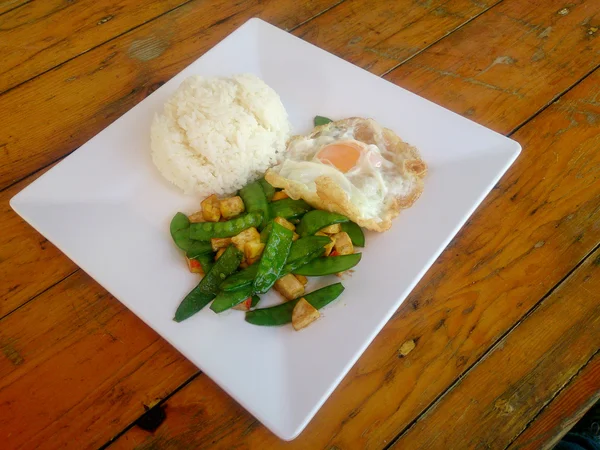 Eine frische grüne Erbse mit Tofu auf weißem Teller unter Rühren gebraten. Vegetarisches Essen, gesunde Ernährung. — Stockfoto