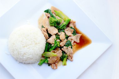 Beyaz arka plan, Tayland gıda üzerinde beyaz tabak pirinç soslu domuz eti ile tavada kızartılmış brokoli.