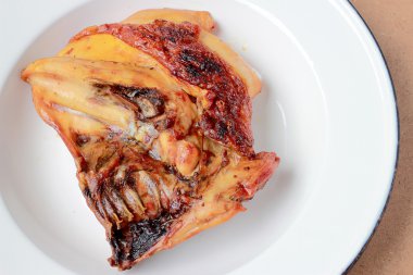 Ahşap masa üzerinde beyaz tabak ızgara tavuk göğsü