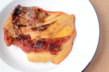 Ahşap masa üzerinde beyaz tabak ızgara tavuk göğsü