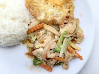 Stir fry sebze tavuk fileto ile yumurta beyaz arka plan üzerinde beyaz tabak pirinç kızarmış.