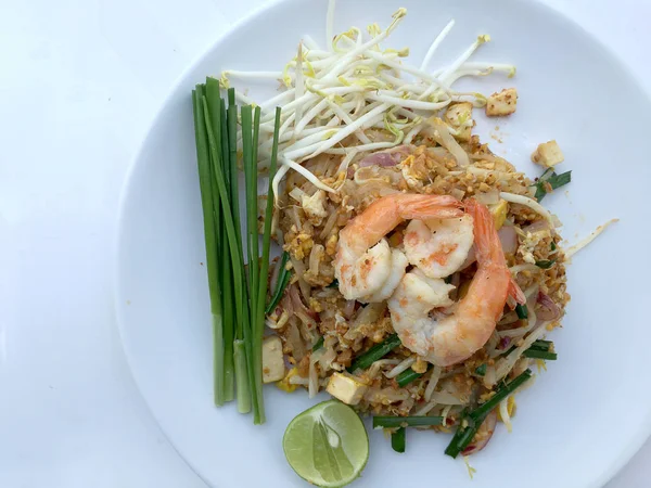 Yastık tavada kızartılmış Tay, Pirinç Noodle ile beyaz arka plan üzerinde beyaz tabak karides. Tayland'ın ulusal ana yemek biri. Tayland popüler gıda. Tayland kızarmış noodle — Stok fotoğraf