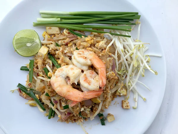 Almofada tailandesa, macarrão de arroz frito com camarão em prato branco no fundo branco. O prato principal nacional da Tailândia. a comida popular na Tailândia. Macarrão frito tailandês — Fotografia de Stock