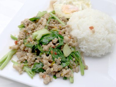 Yakından heyecan ile tepesinde pirinç kızarmış kıyılmış domuz eti ve fesleğen, Tayland gıda.