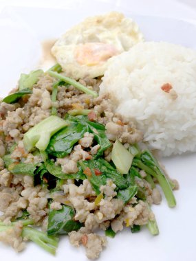 Yakından heyecan ile tepesinde pirinç kızarmış kıyılmış domuz eti ve fesleğen, Tayland gıda.