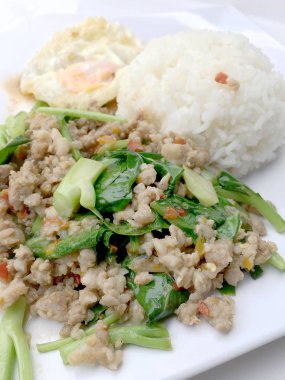 Yakından heyecan ile tepesinde pirinç kızarmış kıyılmış domuz eti ve fesleğen, Tayland gıda.