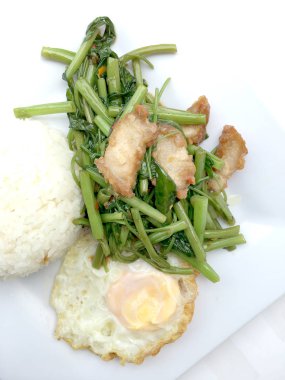 Biber ve soya sosu ve üzerinde beyaz tabak beyaz arka plan üzerinde Tayland gıda izole gevrek domuz kızarmış su ıspanak karıştırın.