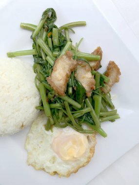 Biber ve soya sosu ve üzerinde beyaz tabak beyaz arka plan üzerinde Tayland gıda izole gevrek domuz kızarmış su ıspanak karıştırın.