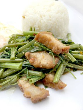 Biber ve soya sosu ve üzerinde beyaz tabak beyaz arka plan üzerinde Tayland gıda izole gevrek domuz kızarmış su ıspanak karıştırın.