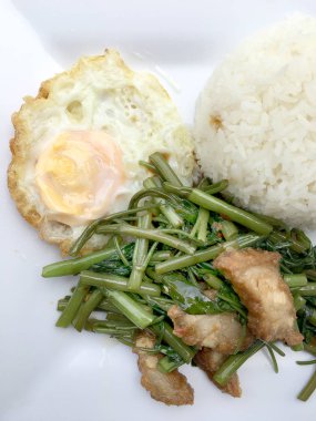 Biber ve soya sosu ve üzerinde beyaz tabak beyaz arka plan üzerinde Tayland gıda izole gevrek domuz kızarmış su ıspanak karıştırın.