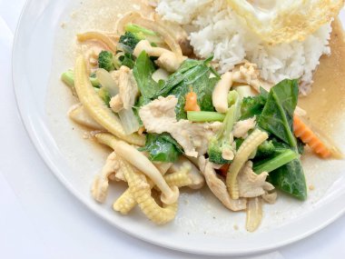 Beyaz arka plan üzerinde beyaz tabak pirinç ile tavada kızartılmış karışık sebze.