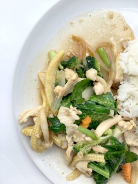 Beyaz arka plan üzerinde beyaz tabak pirinç ile tavada kızartılmış karışık sebze.