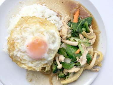 Beyaz arka plan üzerinde beyaz tabak pirinç ile tavada kızartılmış karışık sebze.