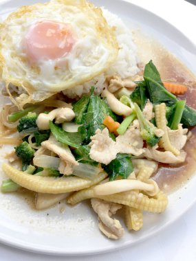 Beyaz arka plan üzerinde beyaz tabak pirinç ile tavada kızartılmış karışık sebze.