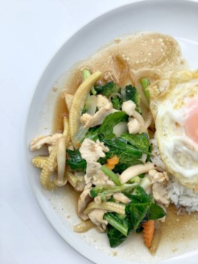 Beyaz arka plan üzerinde beyaz tabak pirinç ile tavada kızartılmış karışık sebze.