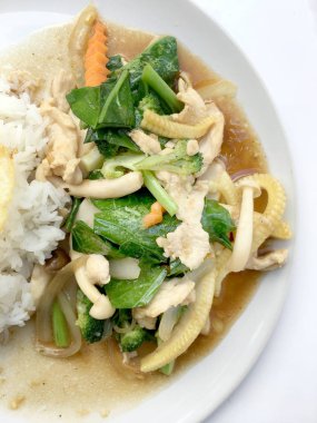 Beyaz arka plan üzerinde beyaz tabak pirinç ile tavada kızartılmış karışık sebze.