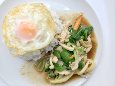 Beyaz arka plan üzerinde beyaz tabak pirinç ile tavada kızartılmış karışık sebze.