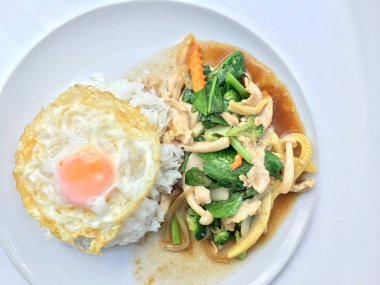 Beyaz arka plan üzerinde beyaz tabak pirinç ile tavada kızartılmış karışık sebze.