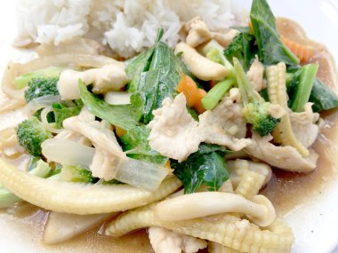 Beyaz arka plan üzerinde beyaz tabak pirinç ile tavada kızartılmış karışık sebze.