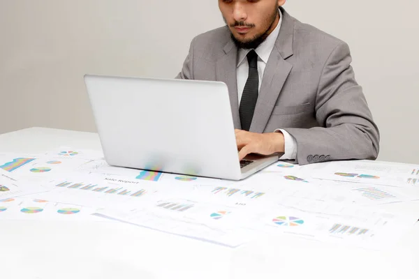 Homem novo que trabalha com o portátil, mãos do homem no computador do caderno, pessoa do negócio no local de trabalho sobre papéis do relatório de negócios, dados, estatística — Fotografia de Stock