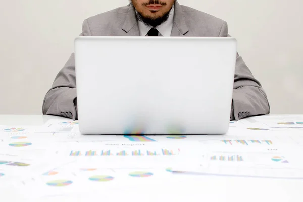 Homem novo que trabalha com o portátil, mãos do homem no computador do caderno, pessoa do negócio no local de trabalho sobre papéis do relatório de negócios, dados, estatística — Fotografia de Stock