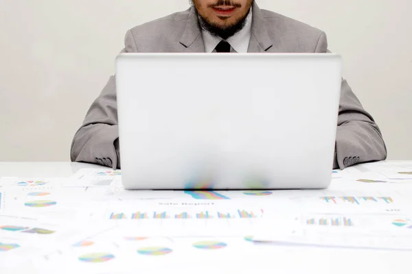 Молодий чоловік, що працює з ноутбуком, руки людини на ноутбуці, бізнесмен на робочому місці над паперами ділового звіту, даними, статистикою — стокове фото