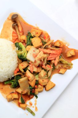 Kızarmış Tofu karışık sebze ve et suyu sosu ile beyaz arka plan üzerinde beyaz tabak ilave edin. Vejetaryen yiyecekler, sağlıklı gıda.