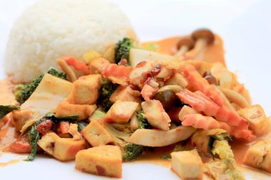 Kızarmış Tofu karışık sebze ve et suyu sosu ile beyaz arka plan üzerinde beyaz tabak ilave edin. Vejetaryen yiyecekler, sağlıklı gıda.