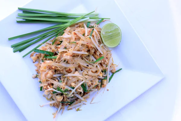 Almofada tailandesa, macarrão de arroz frito com camarão em prato branco isolado no fundo branco. O prato principal nacional da Tailândia. a comida popular. Macarrão frito tailandês — Fotografia de Stock