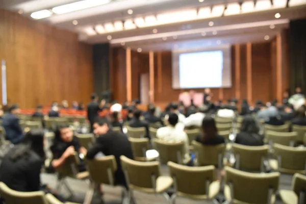 Verschwommenes Bild von Bildungsexperten und Geschäftsleuten, die im Konferenzraum für Berufsseminare sitzen und der Redner präsentiert neue Technologie und Ideenaustausch mit der inhaltlichen Aktivität. — Stockfoto