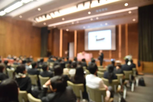 Verschwommenes Bild von Bildungsexperten und Geschäftsleuten, die im Konferenzraum für Berufsseminare sitzen und der Redner präsentiert neue Technologie und Ideenaustausch mit der inhaltlichen Aktivität. — Stockfoto