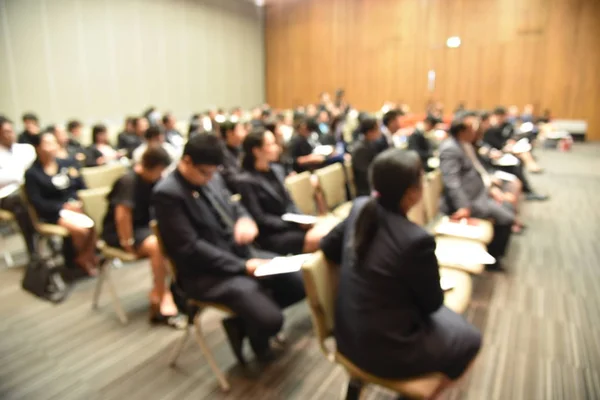 Wazig beeld van onderwijs mensen en mensen uit het bedrijfsleven zitten in de conferentiezaal voor beroep seminar en de spreker is de presentatie van nieuwe technologie en idee te delen met de inhoud activiteit. — Stockfoto