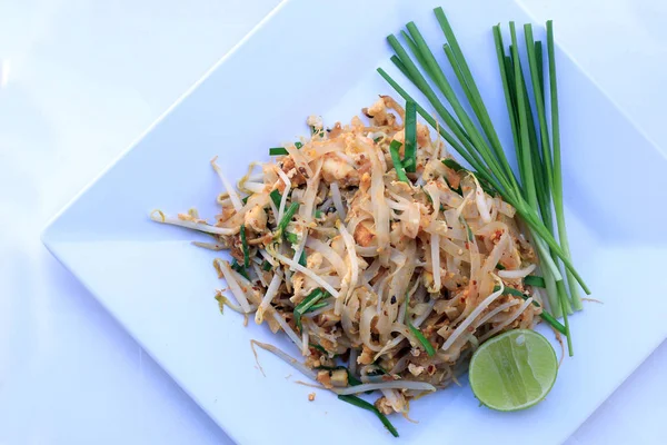 Pad Thai, stir-fried rice noodles with shrimp in white dish isolated on white background. The one of Thailand's national main dish. the popular food. Thai Fried Noodles