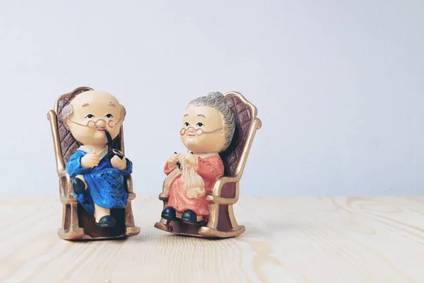 Бабуся і дідусь ляльки в китайському однорідному стилі стоять на дерев'яному тлі. в китайському новому році — стокове фото
