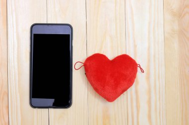 Ahşap arka plan, üstten görünüm üzerinde kırmızı kalpler ile akıllı telefon