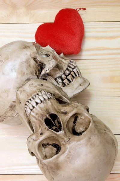 Lidská lebka s červeným srdcem na dřevěné pozadí, pohled shora. Obraz Zátiší a výběr zaměření — Stock fotografie